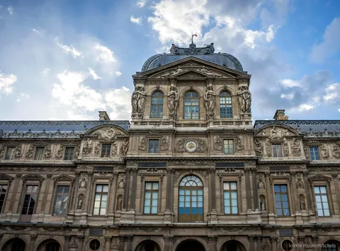 Pavillon de l'Horloge du Louvre avec dôme et statues sous un ciel bleu, à découvrir avec des billets musée du Louvre