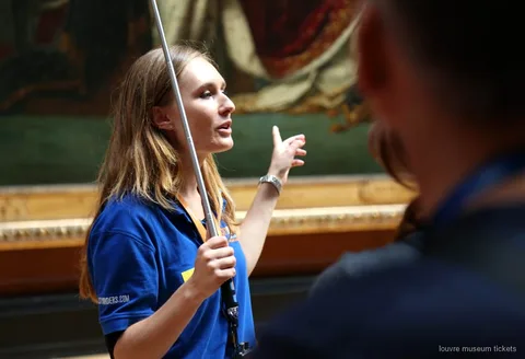 Guide som leder en liten grupp förbi Louvrens mästerverk, bland annat Mona Lisa