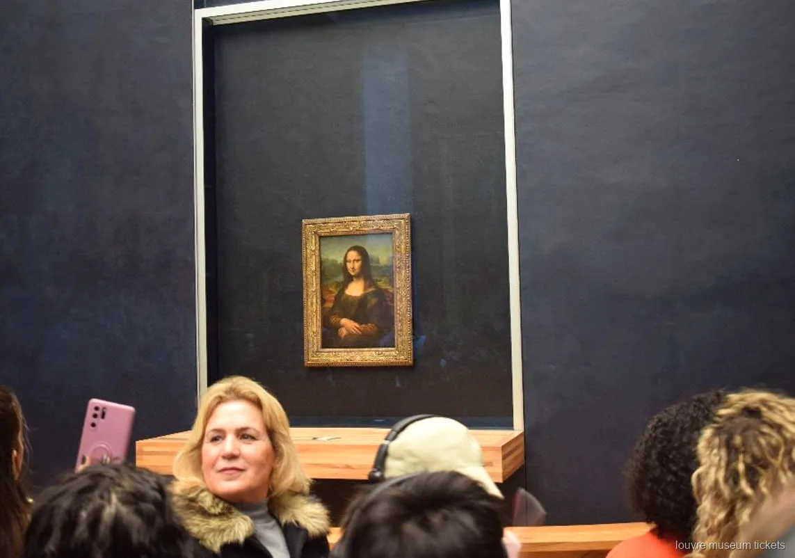 Besucher vor der Mona Lisa hinter Glas an der dunklen Saalwand, ein Höhepunkt der Führung mit Louvre Tickets