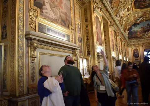 Apollon Galerisi'nin boyalı ve yaldızlı tavanına bakan küçük grup, Louvre Müzesi biletleri ile gezilen salon