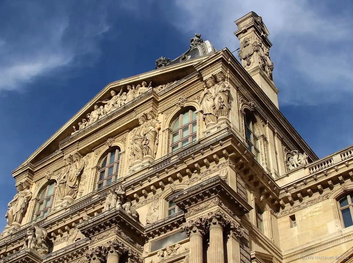 Mavi gökyüzüne karşı heykelli, alınlıklı ve sütunlu Louvre cephesi, Louvre Müzesi biletleri ile görülen yapı