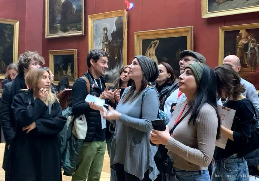 Liten grupp om sex gäster på en guidad visning av Louvren nära Venus de Milo
