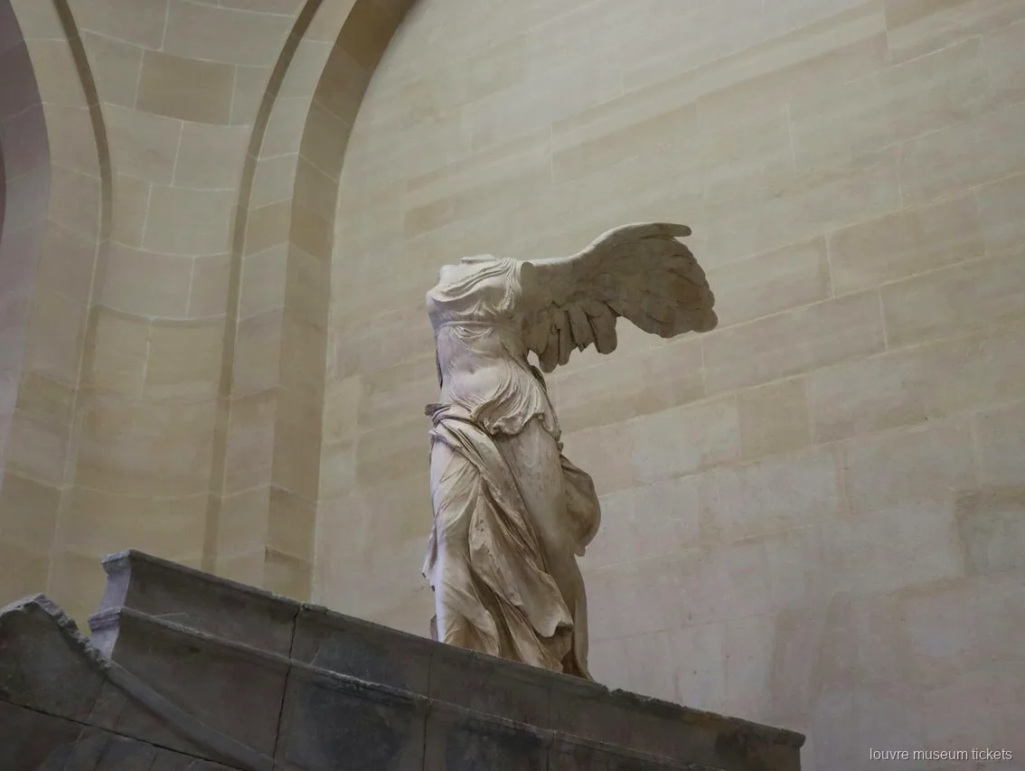 La Nike di Samotracia sulla sua base in pietra a forma di prua, una tappa della visita con biglietti Museo del Louvre