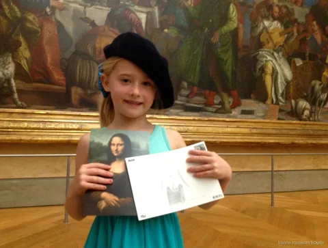 Niña con boina muestra una postal de la Mona Lisa y su dibujo en un tour familiar con entradas al Museo del Louvre