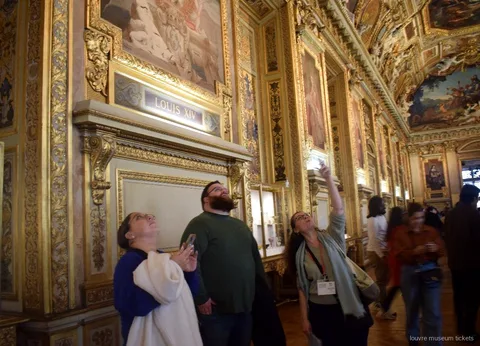 Petit grup mirant el sostre pintat i daurat de la Galeria d'Apol·lo, sala visitada amb entrades del Museu del Louvre