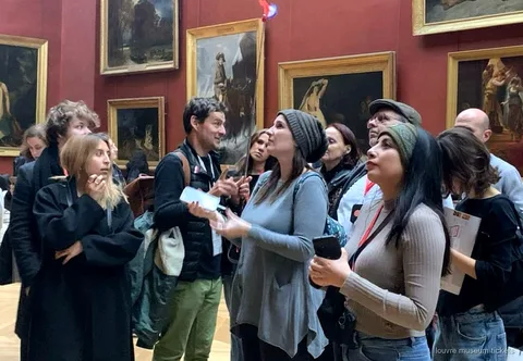 Grupo reduzido de seis pessoas em visita guiada ao Museu do Louvre junto à Vénus de Milo