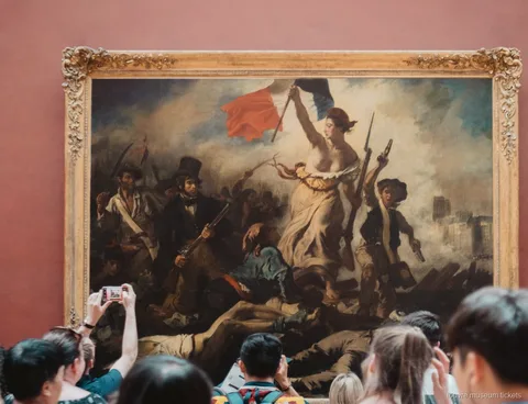 Visitants fotografiant La Llibertat guiant el poble de Delacroix, obra vista amb entrades del Museu del Louvre