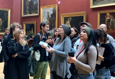 Petit groupe de six personnes lors d'une visite guidée du musée du Louvre près de la Vénus de Milo