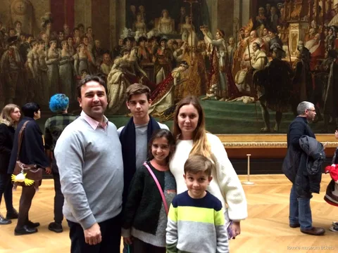 Famille de cinq posant devant le Sacre de Napoléon lors d'une visite privée avec billets du musée du Louvre